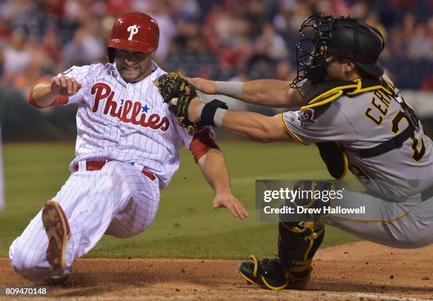 Daniel Nava of the Philadelphia Phillies gets tagged out at home plate by Francisco Cervelli of the Pittsburgh Pirates in the seventh inning at...