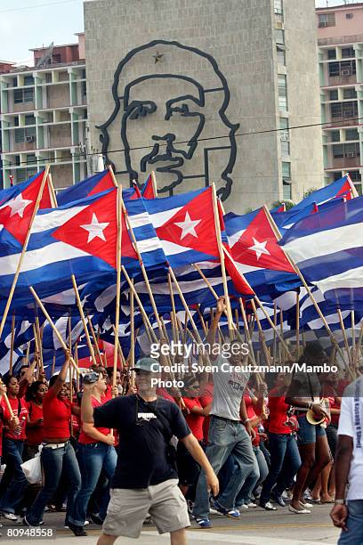 Thousands march with the Cuban flag in front of the Che Guevara image at the Ministry of Interior at the Revolution Square to celebrate the annual...
