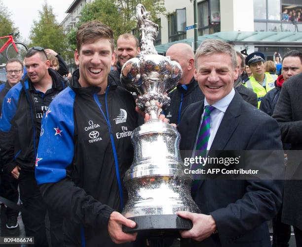 Helmsman Peter Burling and New Zealand Prime Minister Bill English pose with the America's Cup yachting trophy as members of the Emirates Team New...