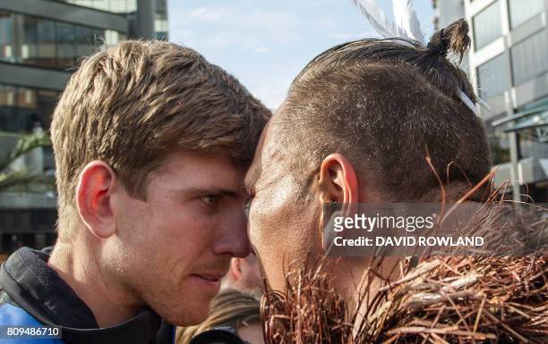 Helmsman Peter Burling receives a hongi from a local Maori Warrior as the Emirates Team New Zealand parades the America's Cup yachting trophy through...