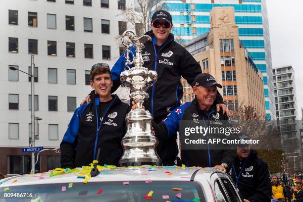 Helmsman Peter Burling, skipper Grant Ashby and CEO Grant Dalton of Emirates Team New Zealand parades the America's Cup yachting trophy through the...