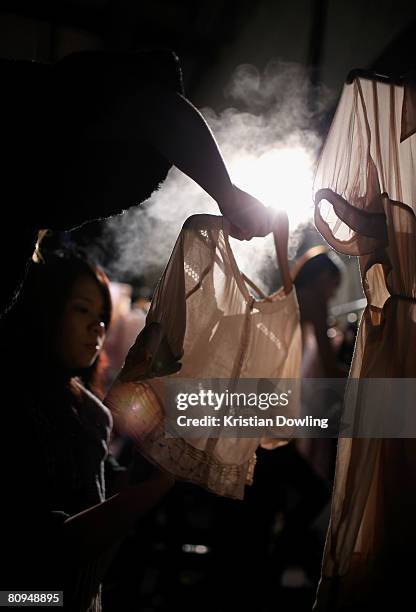 Assistants prepare an outfit backstage prior to the Shakuhachi show during the fourth day of the Rosemount Australian Fashion Week Spring/Summer...