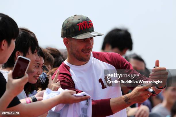 Vissel Kobe new player Lukas Podolski takes selfie with Japanese football fans during the welcome ceremony at the Kobe Airport on July 6, 2017 in...