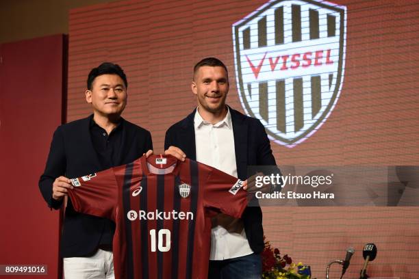 Vissel Kobe new player Lukas Podolski poses with his new jersey next to Rakuten CEO Hiroshi Mikitani during a press conference on July 6, 2017 in...