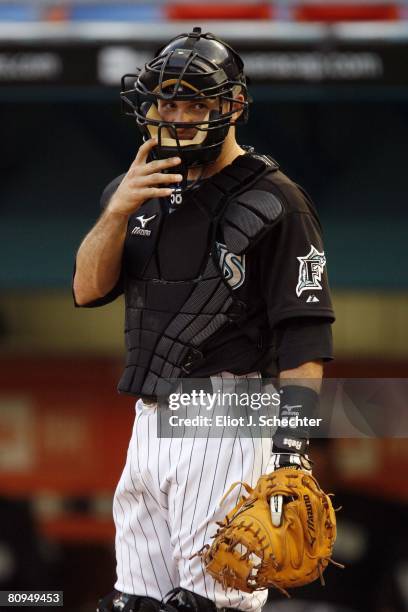 Catcher Mike Rabelo of the Florida Marlins adjusts his mask between pitches against the Los Angeles Dodgers on April 30, 2008 at Dolphin Stadium in...