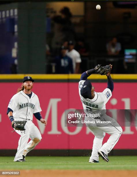 Ben Gamel of the Seattle Mariners watches as Jean Segura of the Seattle Mariners catches a ball hit by Jorge Bonifacio of the Kansas City Royals in...