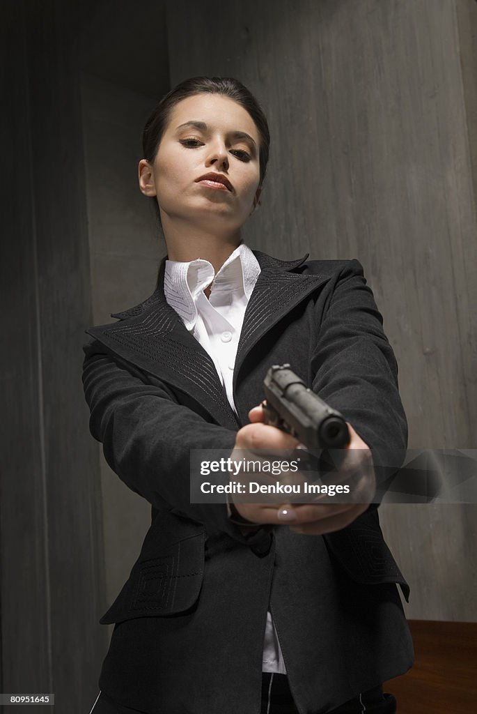 Young businesswoman holding gun