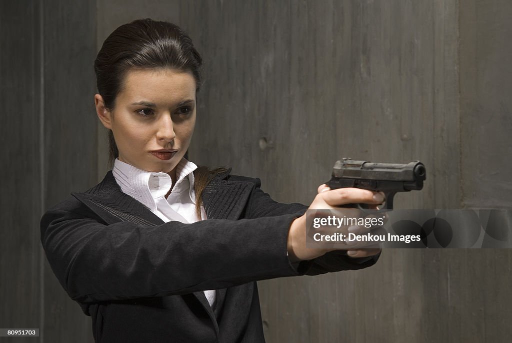 Young businesswoman holding gun