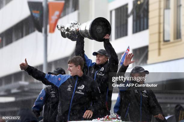 Helmsman Peter Burling , skipper Glenn Ashby and CEO Grant Dalton celebrate as Emirates Team New Zealand parades the America's Cup through the...