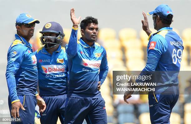 Sri Lankan cricketer Wanidu Hasaranga celebrates with his teammates after he dismissed Zimbabwe cricketer Craig Ervine during the third one-day...