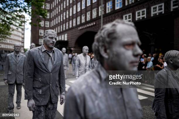 Germany, Hamburg on 7 July 2017. In the art performance the protagonists wear encrusted clothes and stand for a society that has emerged from its...