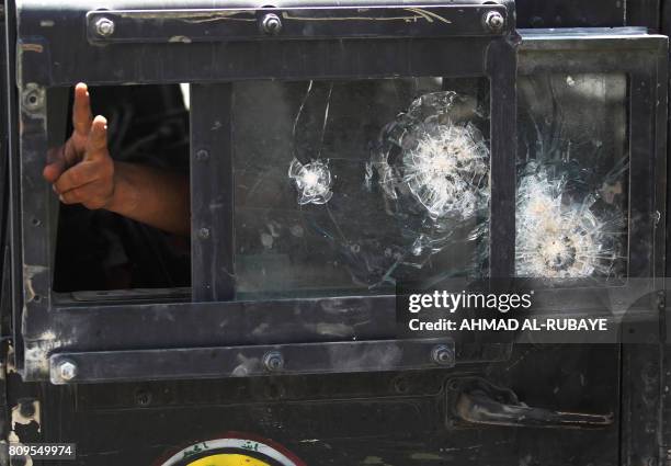 Member of the Iraqi Counter-Terrorism Service flashes the victory sign from the window of a humvee during an advance in the old city of Mosul on July...