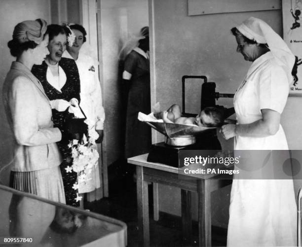 **Scanned from contact low-res** The Queen watches as a baby is weighed at the Karitane Hospital, Anderson's Bay, Dunedin.