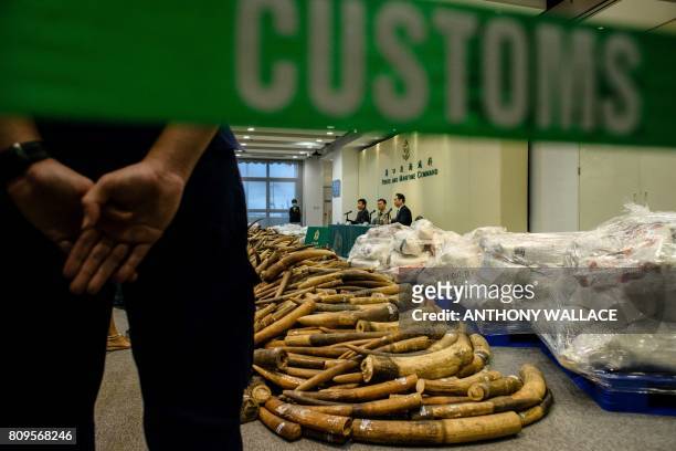 Customs officer stands guard next to seized elephant ivory tusks during a press conference at the Kwai Chung Customhouse Cargo Examination Compound...
