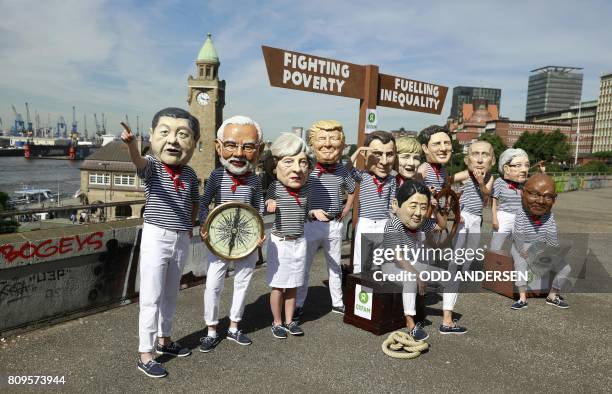 Anti-capitalism activists wearing masks featuring China's President Xi Jinping, India's Prime Minister Narendra Modi, Britain's Prime Minister...