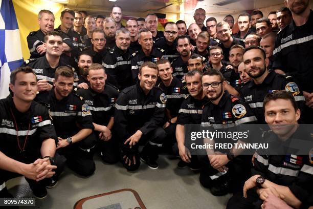 In this photograph taken at sea on July 4 French president Emmanuel Macron poses with the crew of SSBN submarine "Le Terrible" during a visit to the...