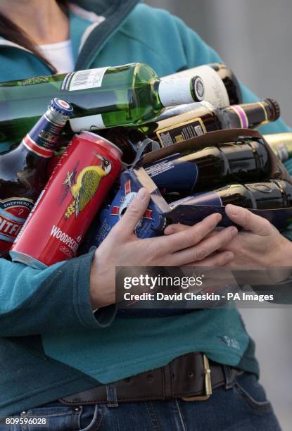 Person holds an armful of assorted alcoholic drinks as the Scottish Government has reintroduced its plan for minimum alcohol pricing.