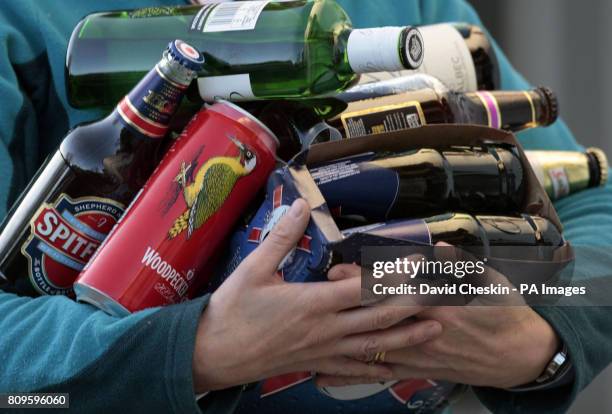 Person holds an armful of assorted alcoholic drinks as the Scottish Government has reintroduced its plan for minimum alcohol pricing.