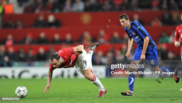 Manchester United's Dimitar Berbatov battles for the ball with Otelul Galati's Loan Filip during the UEFA Champions League match at Old Trafford,...