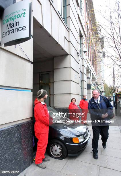 Greenpeace protesters use a car to block the main entrance to the Department for Transport in Horseferry Road, London, after they claimed documents...