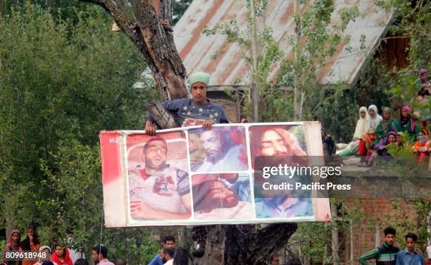 Kashmiri boy displays picture of commander Burhan Wani during the funeral prayers of Jehangir Ahmad Khanday of Keller area of Shopian district. Six...
