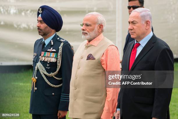 Indian Prime Minister Narendra Modi and Israeli Prime Minister Benjamin Netanyahu stand alongside an Indian army officer at the Indian Army Cemetery...