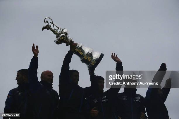 Members of Emirates Team New Zealand lift the America's Cup trophy in celebration during the Team New Zealand Americas Cup Welcome Home Parade on...