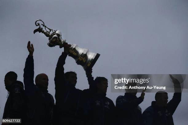 Members of Emirates Team New Zealand lift the America's Cup trophy in celebration during the Team New Zealand Americas Cup Welcome Home Parade on...