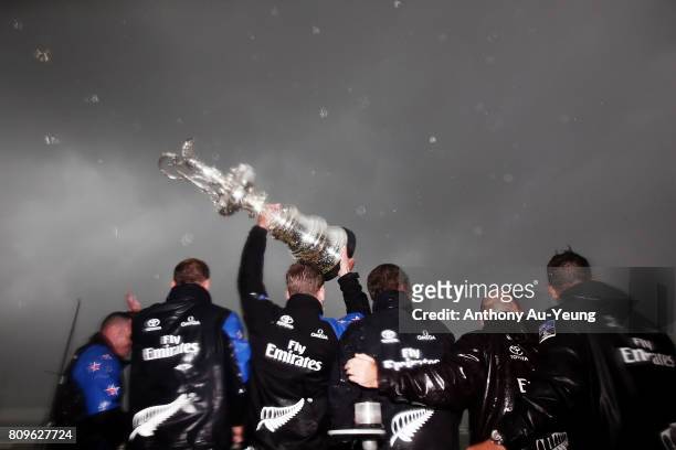 Members of Emirates Team New Zealand lift the America's Cup trophy in celebration during the Team New Zealand Americas Cup Welcome Home Parade on...