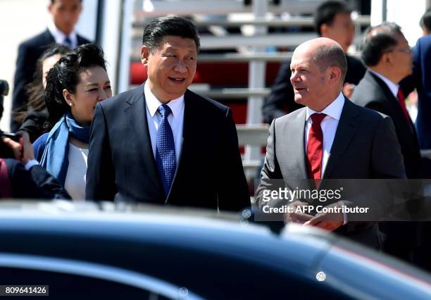 Hamburg's mayor Olaf Scholz welcomes China's President Xi Jinping and his wife Peng Liyuan as they arrive at the airport in Hamburg, northern Germany...