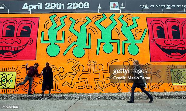 People walk by a re-creation of an untitled mural painted by artist Keith Haring on the corner of Houston Street and Bowery in Manhattan May 2, 2008...