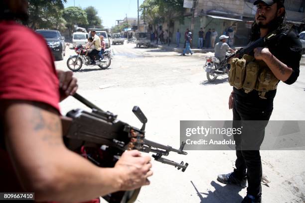 Syrian men stand guard with heavy machine guns after the Operation Euphrates Shield in Jarabulus district of Aleppo, Syria on July 06, 2017.