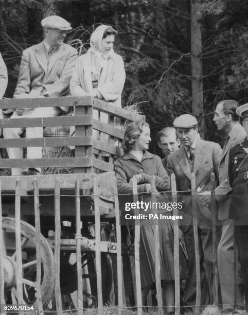 Queen Elizabeth II sits beside her host, the Duke of Beaufort, in a farm wagon used as a grandstand, to watch the endurance tests at the Three Day...