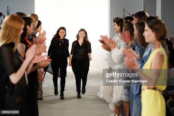 Designers Caroline Rohner and Inna Stein acknowledge the applause of the audience at the Steinrohner show during the Mercedes-Benz Fashion Week...
