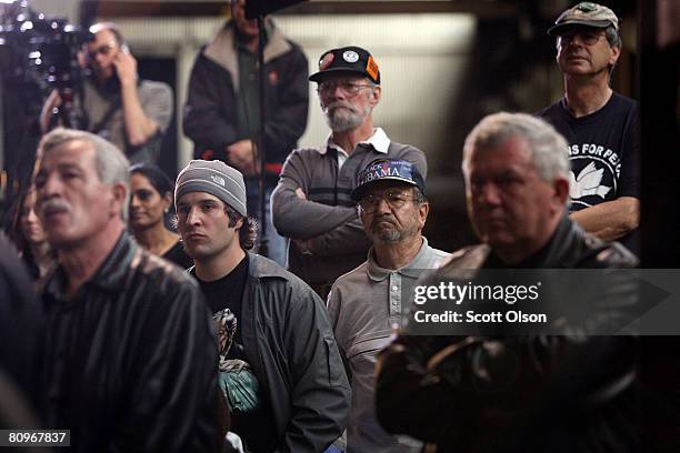 Workers listen as Democratic presidential candidate Senator Barack Obama speaks at a town hall stlye meeting at the Munster Steel Company May 2, 2008...