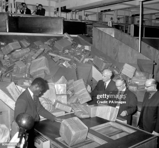 Postmaster General Edward Short watching the highly mechanised sorting machine dealing with the mountains of Christmas mail at the new Western...