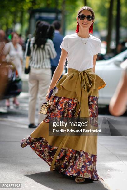 Guest wears sunglasses, a white t-shirt, a flower print skirt, outside the Zuhair Murad, during Paris Fashion Week - Haute Couture Fall/Winter...