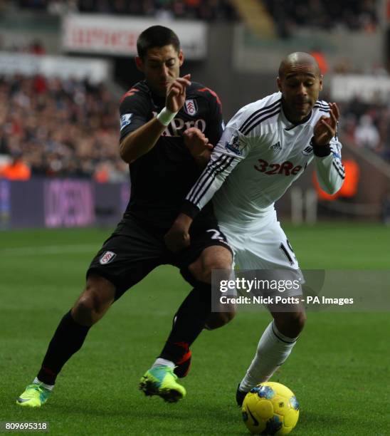 Fulham's Clint Dempsey tussles fore the ball with Swansea's Luke Moore during the Barclays Premier League match at the Liberty Stadium, Swansea.