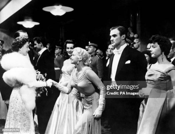 Queen Elizabeth II shakes hands with Hollywood actress Jayne Mansfield at the Royal Film Performance of 'Les Girls' at the Odeon, Leicester Square,...