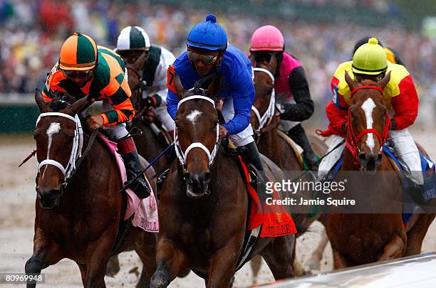 Gabriel Saez, riding Proud Spell and Rajiv Maragh, riding Little Belle lead a pack of horses on the front stretch during the 134th running of the...
