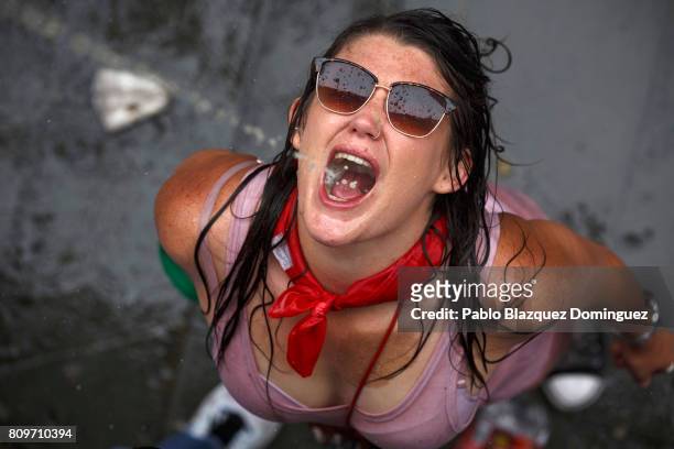 Reveller catches beer thrown from a balcony during the opening day or 'Chupinazo' of the San Fermin Running of the Bulls fiesta on July 6, 2017 in...