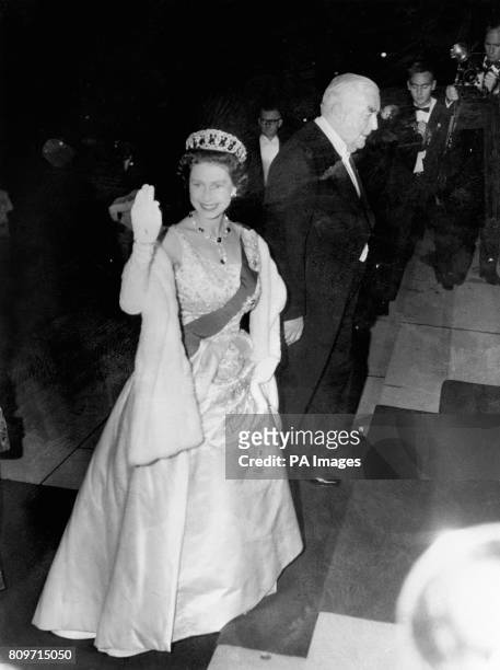 Queen Elizabeth II waves to the crowd as she arrives for a State reception at Parliament House, Canberra. She is escorted by Prime Minister Robert...