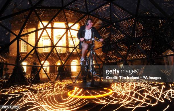 Lighting artist Bruce Munro rides the bike powering his new 'Star Turn' installation at the Holburne Museum in Bath, taking the first hour of a dusk...