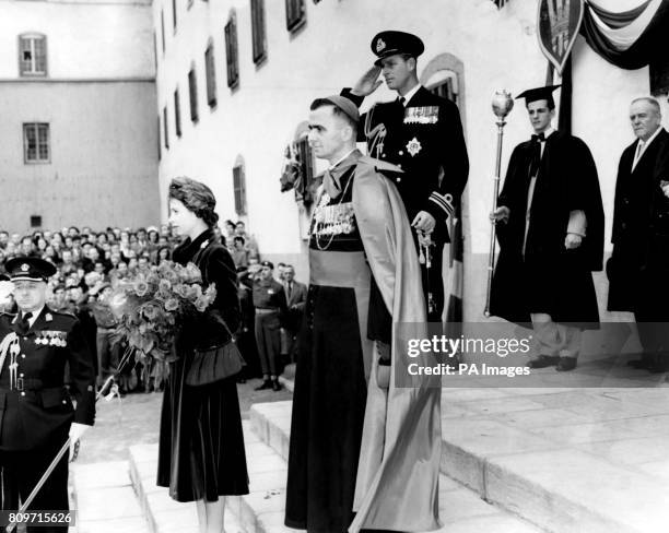 Princess Elizabeth and the Duke of Edinburgh on the steps of Laval University as they hear the English and French rendition of "God Save the King"....