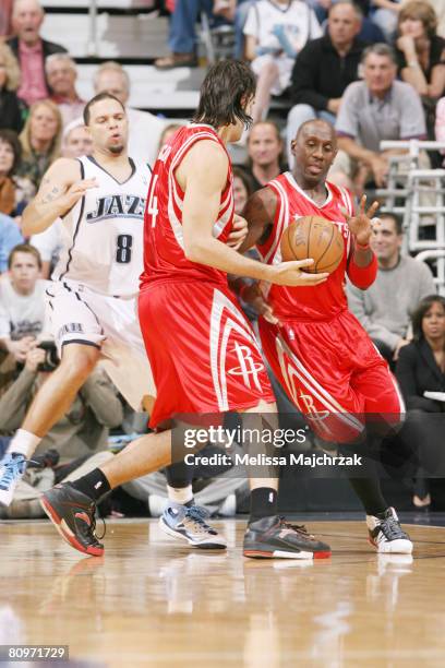 Luis Scola of the Houston Rockets hands the ball off to teammate Bobby Jackson in front of Deron Williams of the Utah Jazz in Game Six of the Western...