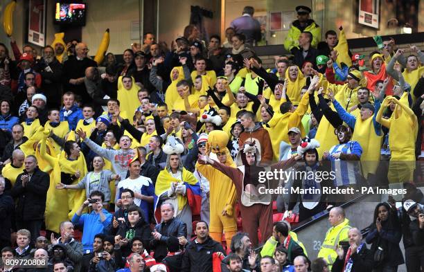 Fans in fancy dress cheer on their side in the stands on Boxing Day