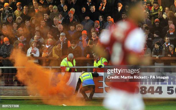 Steward removes a flare thrown by a Blackpool fan during the FA Cup, Third Round match at Highbury Stadium, Fleetwood.