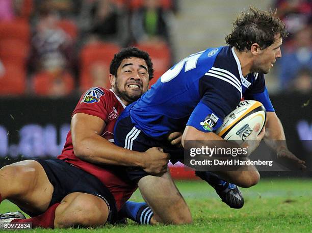 Morgan Turinui of the Reds tackles Nick Evans of the Blues during the round 12 Super 14 match between the Queensland Reds and the Blues at Suncorp...