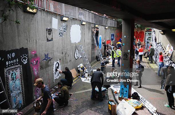 Stencil artists paint the walls of a subway as a giant new exhibition space created by famed graffiti artist Banksy opens to the public on May 3,...