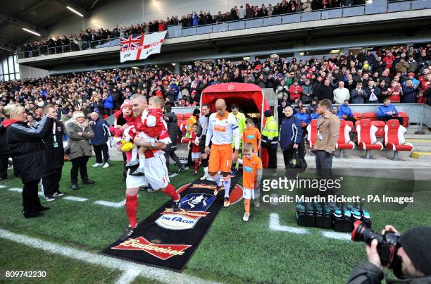Fleetwood Town's Steve McNulty and Blackpool's Alex Baptiste lead the teams out during the FA Cup, Third Round match at Highbury Stadium, Fleetwood.